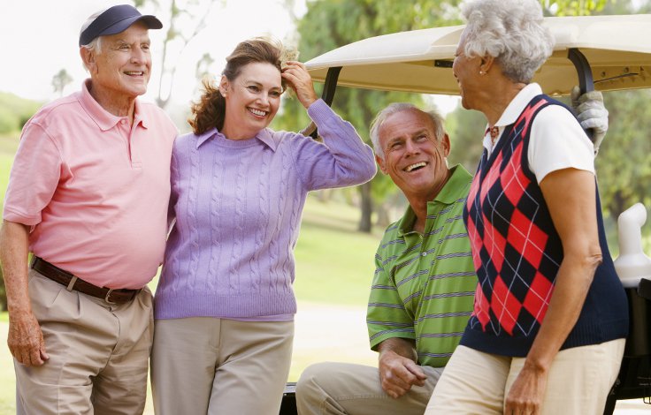 four golfers around a golf cart